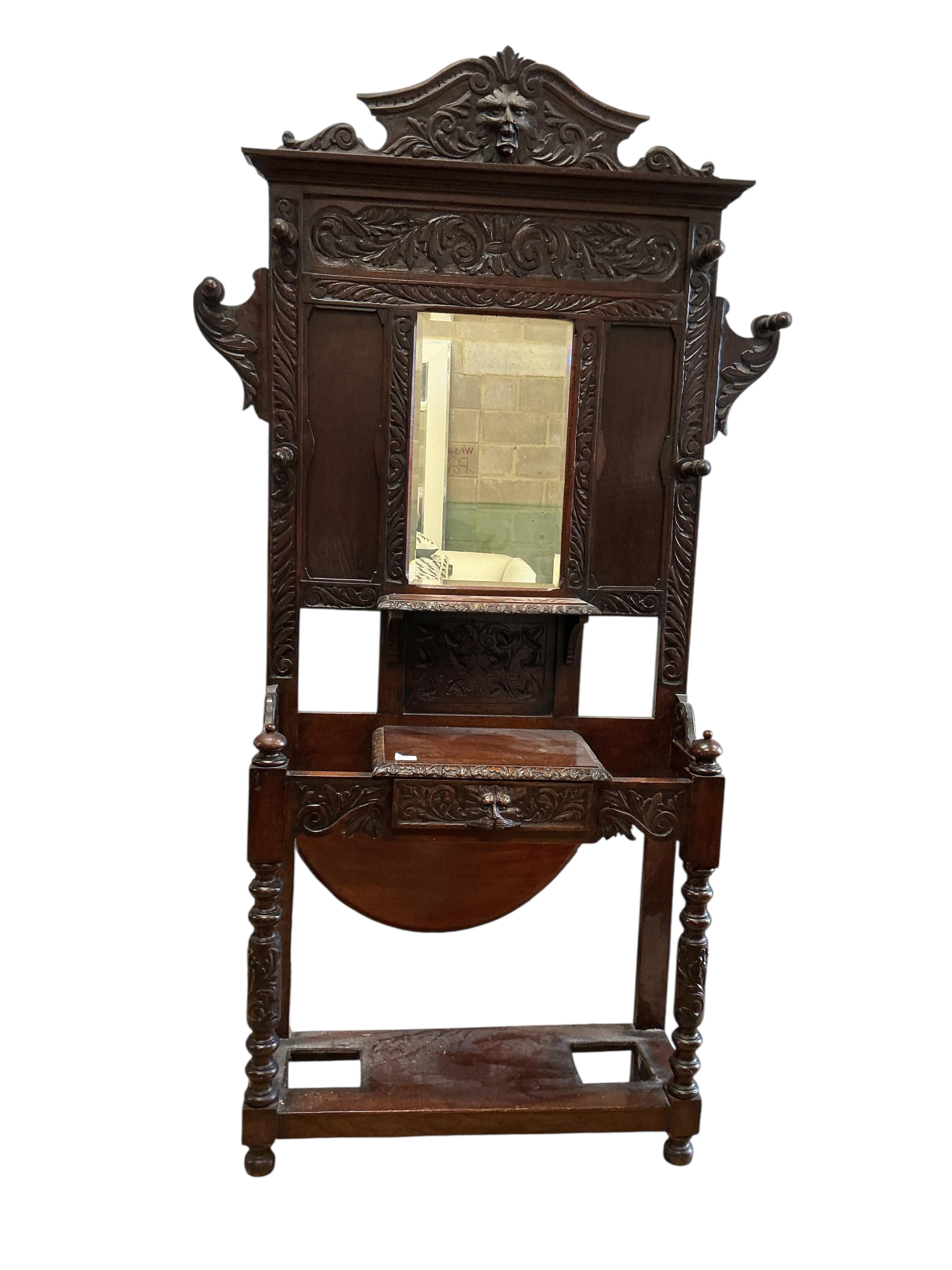 A late Victorian carved oak hall stand, width 120cm, depth 33cm, height 221cm